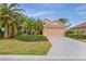 Charming single-story home with a well-manicured lawn, complemented by lush tropical landscaping and an attached two-car garage at 1363 New Forest Ln, Osprey, FL 34229