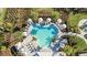 Aerial view of the community pool with tropical landscaping and umbrellas at 16202 Isola Pl, Bradenton, FL 34211
