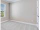 A bedroom with a large window offering ample natural light and neutral-colored walls and carpet at 16202 Isola Pl, Bradenton, FL 34211
