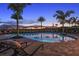 Community pool surrounded by palm trees and lounge chairs, a perfect spot for relaxation and fun at 16202 Isola Pl, Bradenton, FL 34211