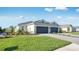 A landscaped front yard leading to a modern home with a two-car garage and well-manicured lawn at 16202 Isola Pl, Bradenton, FL 34211