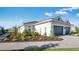 A landscaped front yard leading to a modern home with a two-car garage and well-manicured lawn at 16202 Isola Pl, Bradenton, FL 34211