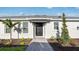 Inviting front entrance featuring a black front door, sidelight, and well-maintained landscaping at 16202 Isola Pl, Bradenton, FL 34211