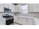 Bright kitchen featuring stainless steel appliances, white cabinets, and a tiled backsplash at 16202 Isola Pl, Bradenton, FL 34211