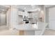 Modern kitchen featuring white cabinets, stainless steel appliances, and a large quartz countertop island at 16202 Isola Pl, Bradenton, FL 34211