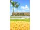 Community signage amid manicured lawns and flower beds under a sunny, blue sky at 16202 Isola Pl, Bradenton, FL 34211