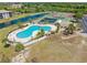 Beautiful aerial view showcases the pool, tennis courts, landscaping and nearby waterway at 175 Kings Hwy # 428 B8, Punta Gorda, FL 33983