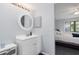 Bright bathroom with white vanity, round mirror, and view into the bedroom at 175 Kings Hwy # 428 B8, Punta Gorda, FL 33983