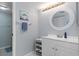 Bright bathroom featuring a white vanity, round mirror, and coastal-themed decor at 175 Kings Hwy # 428 B8, Punta Gorda, FL 33983