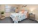 Comfortable bedroom featuring a patterned quilt, side table, and bright natural light at 175 Kings Hwy # 428 B8, Punta Gorda, FL 33983