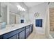 Bathroom featuring a blue vanity with sink, decorative mirror, and shower with curtain at 20228 Lagente Cir, Venice, FL 34293