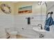 Charming powder room with wainscoting, pedestal sink, and beach-themed decor at 20228 Lagente Cir, Venice, FL 34293