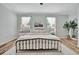 Bright bedroom with a metal frame bed, bedside tables, and light-filled windows at 20228 Lagente Cir, Venice, FL 34293
