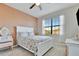 Comfortable bedroom featuring a queen bed, ceiling fan, and bright window at 20228 Lagente Cir, Venice, FL 34293
