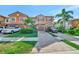 Charming two-story townhome with an attached garage, lush landscaping, and a brick paver driveway at 20228 Lagente Cir, Venice, FL 34293