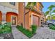 Two-story townhome entrance with a brick paver walkway, colorful landscaping, and attached garage at 20228 Lagente Cir, Venice, FL 34293