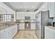 Bright kitchen featuring white cabinets, stainless steel appliances, and granite countertops at 20228 Lagente Cir, Venice, FL 34293