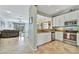 Open kitchen with white cabinetry, stainless steel appliances, and granite countertops overlooking the living area at 20228 Lagente Cir, Venice, FL 34293