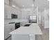 Modern kitchen featuring gray cabinets, stainless steel appliances, and an island with a quartz countertop at 2340 Lindstrom St, Sarasota, FL 34237