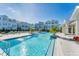 Stunning community pool featuring a zero entry, sun loungers, and lush landscaping around multi-story townhomes at 2340 Lindstrom St, Sarasota, FL 34237