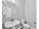 Powder room with pedestal sink, decorative mirror, and tiled flooring at 2340 Lindstrom St, Sarasota, FL 34237