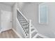 A modern staircase with white risers, wood treads, and wrought iron railings leading to the upper level at 2340 Lindstrom St, Sarasota, FL 34237