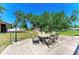 Spacious backyard featuring an outdoor dining set, lush greenery, and additional storage at 2611 221St E St, Bradenton, FL 34211
