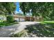 Spacious home exterior with a long driveway, mature trees, green grass, and a two-car garage at 2611 221St E St, Bradenton, FL 34211