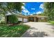 Spacious home exterior with a long driveway, mature trees, green grass, and a two-car garage at 2611 221St E St, Bradenton, FL 34211