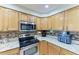 Updated kitchen with stainless steel oven, mosaic backsplash, light countertops, and wooden cabinets at 2611 221St E St, Bradenton, FL 34211