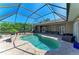 Enclosed pool area featuring a heated pool and spa, with ample seating and a lush green backdrop at 2611 221St E St, Bradenton, FL 34211