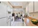 Bright kitchen featuring white cabinets, laminate countertops, and adjacent dining area at 2707 Vinson Ave, Sarasota, FL 34232