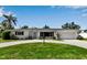 Charming single-story home featuring a well-manicured lawn, circular driveway, and attached two-car garage at 3130 Key Way, Sarasota, FL 34239