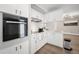 Well-lit, modern kitchen with white cabinets, backsplash, and stainless steel oven and appliances at 3130 Key Way, Sarasota, FL 34239