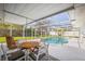 Enclosed pool area with furniture and a bright blue in-ground pool for enjoyment at 3130 Key Way, Sarasota, FL 34239