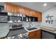 A galley kitchen with wood cabinets, stainless steel appliances and quartz countertop at 3333 26Th E Ave # 1004, Bradenton, FL 34208