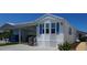 Bright exterior of a well-maintained mobile home with blue shutters, white siding, and a convenient carport at 3333 26Th E Ave # 1257, Bradenton, FL 34208