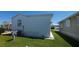 View of the side of a single-Gathering home with white siding, showcasing the well-maintained lawn and adjacent property at 3333 26Th E Ave # 1257, Bradenton, FL 34208