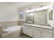 Large bathroom featuring a soaking tub, walk-in shower, and double sinks at 3512 Scrub Creek Run, Lakewood Ranch, FL 34211