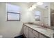 Bright bathroom featuring a granite countertop vanity with double sinks and a large mirror at 3512 Scrub Creek Run, Lakewood Ranch, FL 34211