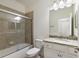 Bathroom featuring a tiled shower, granite countertop vanity, toilet, and framed mirror at 3512 Scrub Creek Run, Lakewood Ranch, FL 34211
