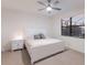 Bright bedroom featuring a white bed set, a large window, and a ceiling fan at 3512 Scrub Creek Run, Lakewood Ranch, FL 34211