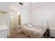 Bright bedroom with light brown carpet, a white bed frame, and an en suite bathroom at 3512 Scrub Creek Run, Lakewood Ranch, FL 34211