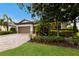 Charming single-story home featuring a two-car garage, lush landscaping, and a brick driveway at 3512 Scrub Creek Run, Lakewood Ranch, FL 34211