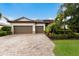 Beautiful single-story home with a two-car garage, brick driveway, and mature landscaping at 3512 Scrub Creek Run, Lakewood Ranch, FL 34211