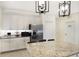 Bright kitchen features granite countertops, stainless steel appliances, and decorative pendant lighting at 3512 Scrub Creek Run, Lakewood Ranch, FL 34211