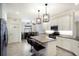 Bright kitchen featuring white cabinets, stainless steel appliances, and a granite island with barstools at 3512 Scrub Creek Run, Lakewood Ranch, FL 34211