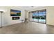 Open living room with tile flooring and a wall of glass overlooking the pool and water at 3512 Scrub Creek Run, Lakewood Ranch, FL 34211