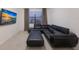 Modern living room with a large sectional sofa, ottoman, and a mounted flatscreen TV at 3512 Scrub Creek Run, Lakewood Ranch, FL 34211