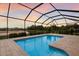 Beautiful screened-in pool area offering a peaceful retreat with tranquil views of the lake at sunset at 3512 Scrub Creek Run, Lakewood Ranch, FL 34211